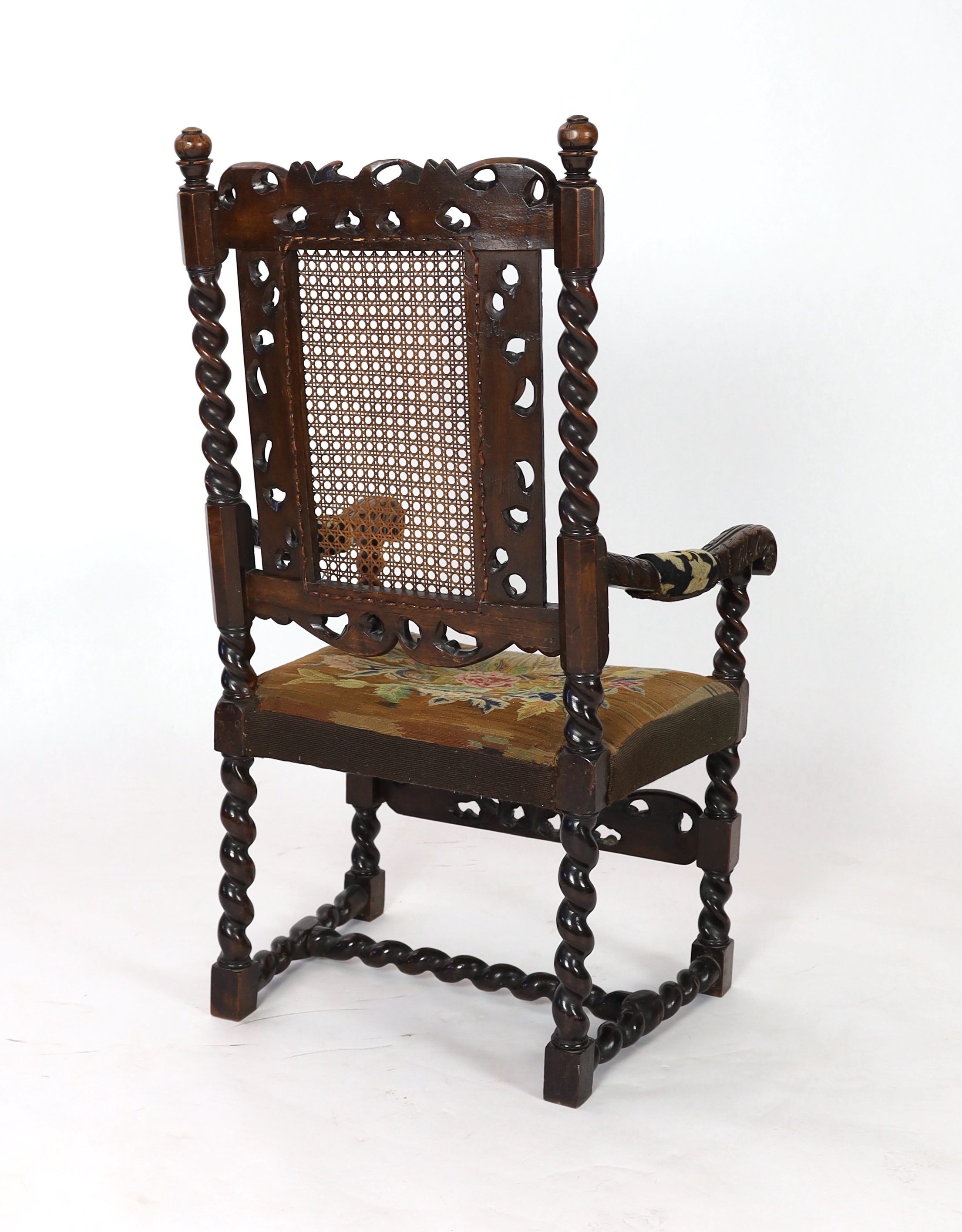 A Charles II carved walnut caned back elbow chair, with a contemporary needlework upholstered seat, c.1670, width 63cm, height 116cm, Please note this lot attracts an additional import tax of 5% on the hammer price